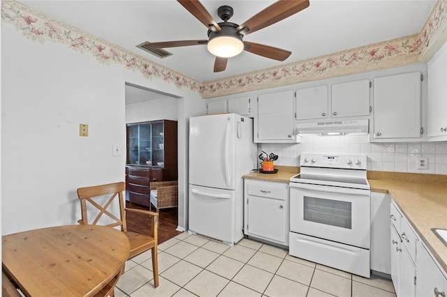 kitchen with light tile patterned floors, white appliances, white cabinets, and backsplash