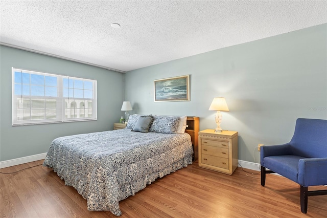 bedroom featuring light hardwood / wood-style flooring and a textured ceiling