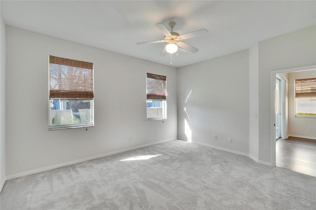 carpeted empty room with a wealth of natural light and ceiling fan