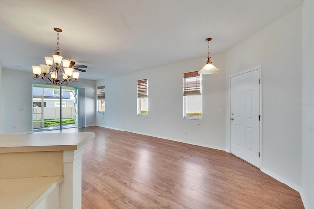 unfurnished living room with hardwood / wood-style floors and a chandelier