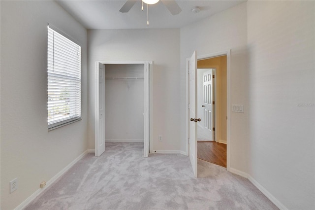 unfurnished bedroom with light carpet, ceiling fan, and a closet