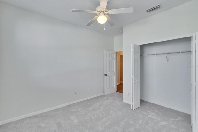 unfurnished bedroom featuring light carpet, a closet, and ceiling fan