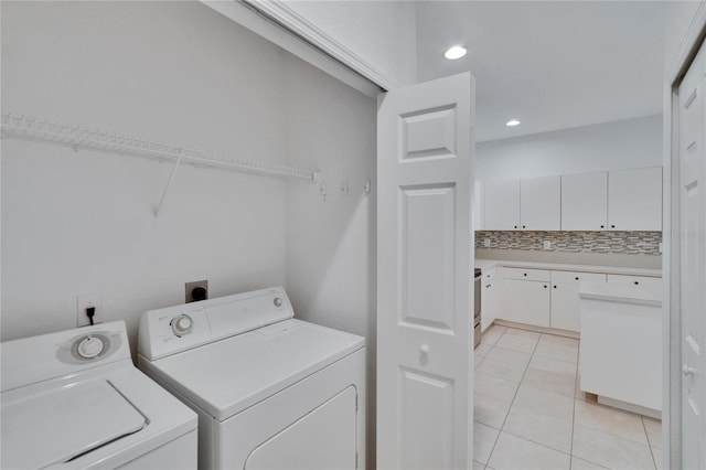 laundry room featuring washing machine and dryer and light tile patterned floors