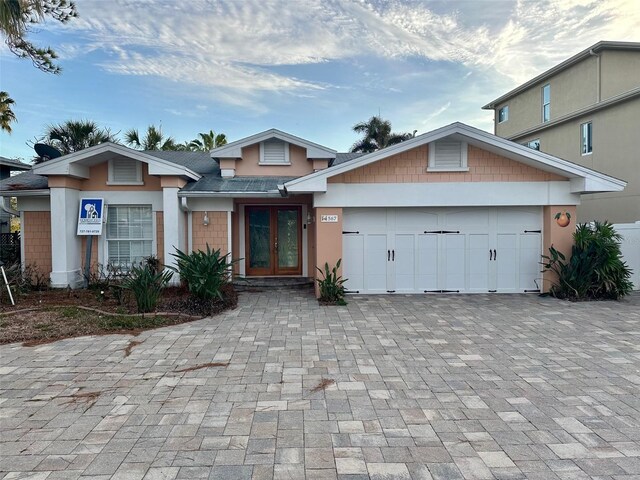 view of front of home with a garage and french doors