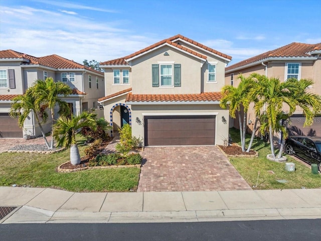 mediterranean / spanish home featuring a garage and a front lawn