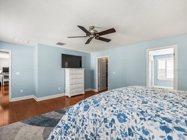 bedroom featuring ceiling fan, dark wood-type flooring, and a textured ceiling