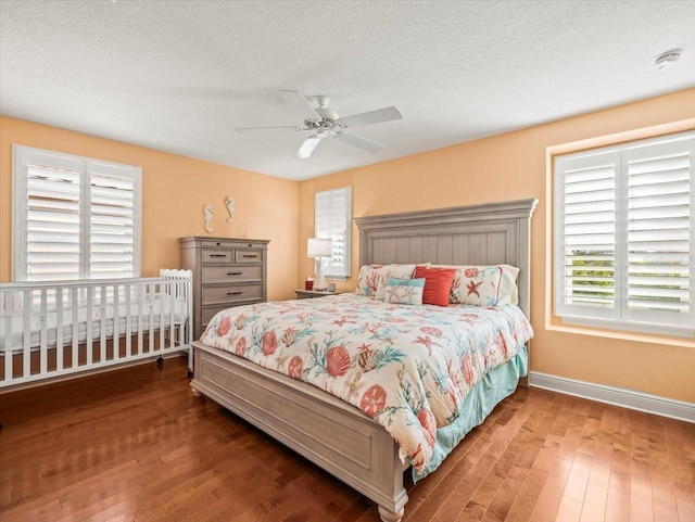 bedroom with hardwood / wood-style flooring, ceiling fan, and a textured ceiling