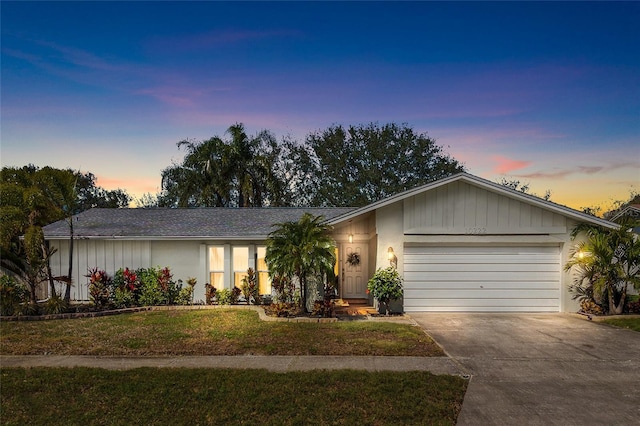 ranch-style home featuring a yard and a garage