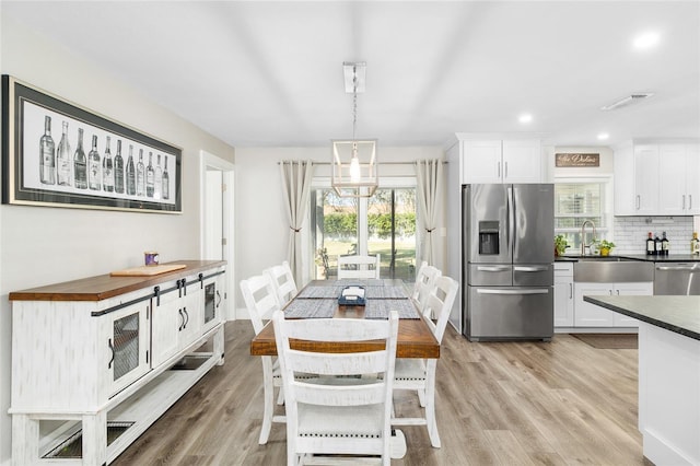 dining area featuring sink and light hardwood / wood-style floors