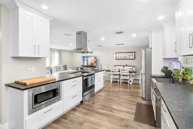 kitchen featuring island range hood, sink, white cabinets, light hardwood / wood-style floors, and stainless steel appliances