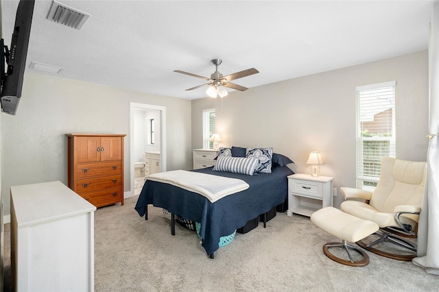 carpeted bedroom with ceiling fan and connected bathroom