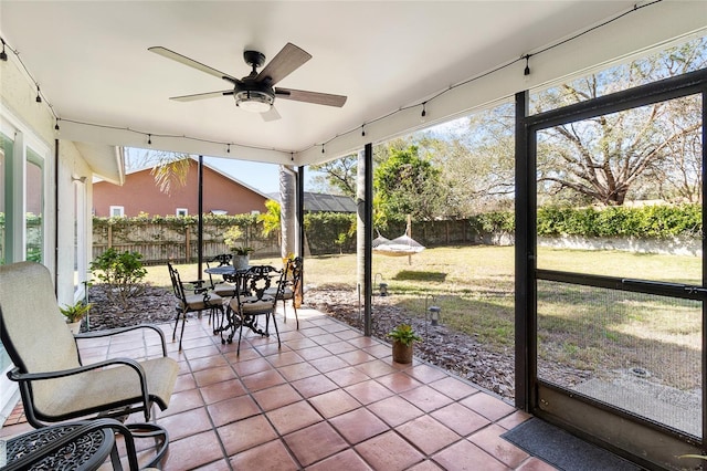 unfurnished sunroom with ceiling fan