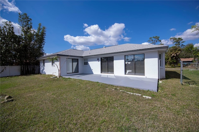 rear view of property featuring a patio area and a lawn