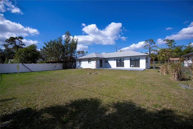 rear view of property featuring a yard