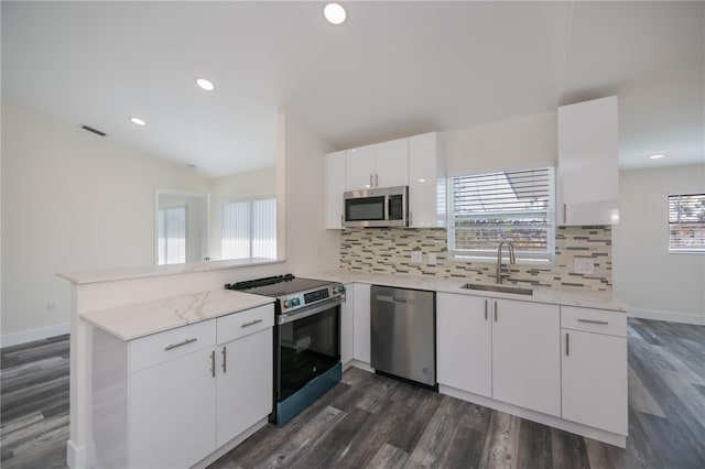 kitchen featuring sink, white cabinetry, tasteful backsplash, kitchen peninsula, and stainless steel appliances