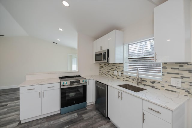 kitchen featuring sink, white cabinetry, light stone counters, appliances with stainless steel finishes, and kitchen peninsula