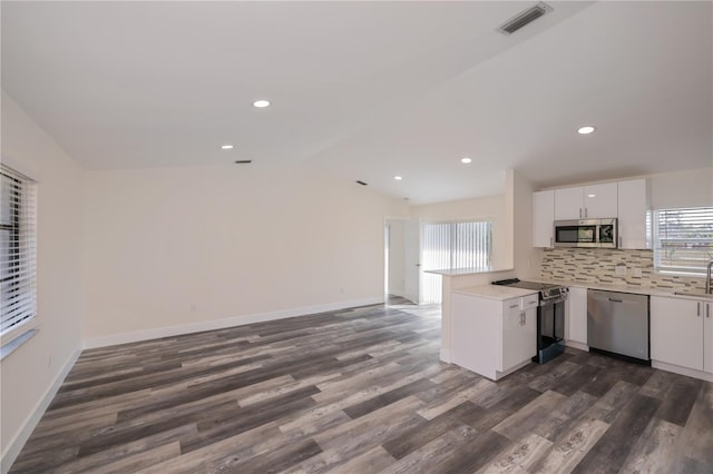 kitchen featuring appliances with stainless steel finishes, sink, white cabinets, decorative backsplash, and kitchen peninsula