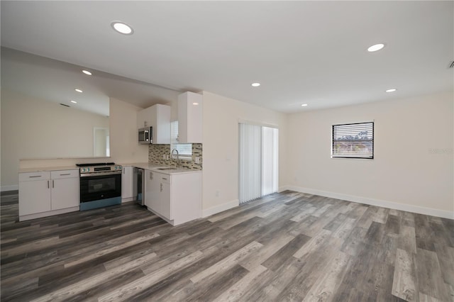 kitchen featuring sink, white cabinetry, backsplash, stainless steel appliances, and dark hardwood / wood-style floors