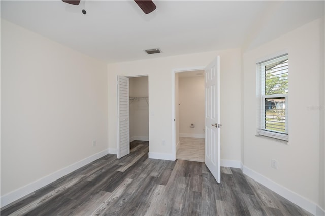 unfurnished bedroom featuring a closet, dark hardwood / wood-style floors, and ceiling fan