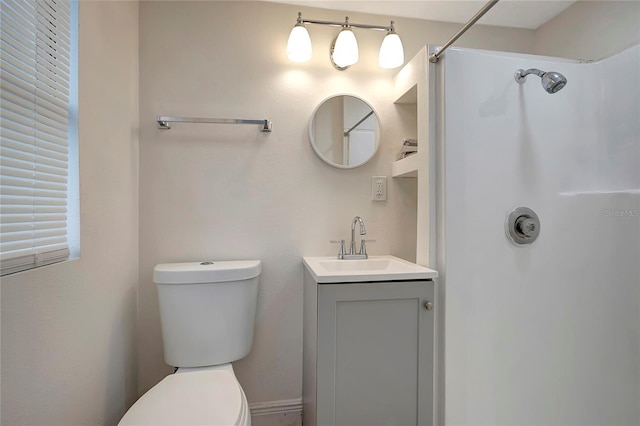 bathroom featuring vanity, a shower, and toilet