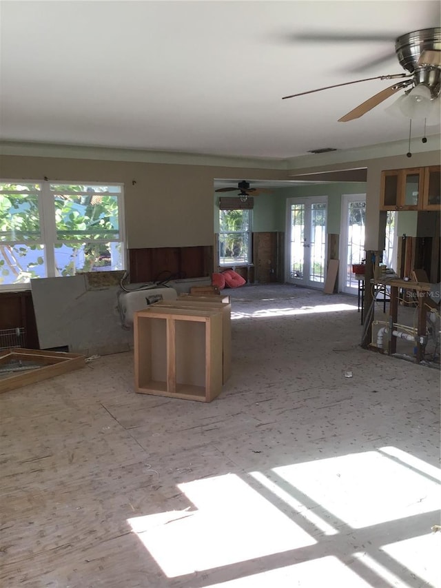 kitchen with a ceiling fan, a wainscoted wall, visible vents, french doors, and open floor plan