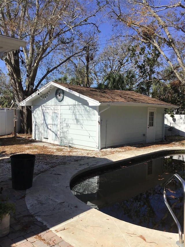 view of property exterior with an outdoor pool and fence