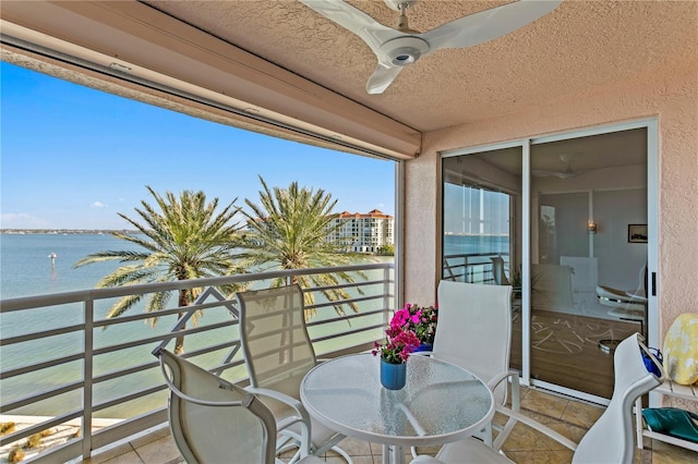 balcony with ceiling fan and a water view