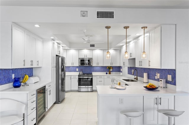 kitchen featuring sink, kitchen peninsula, stainless steel appliances, beverage cooler, and white cabinets