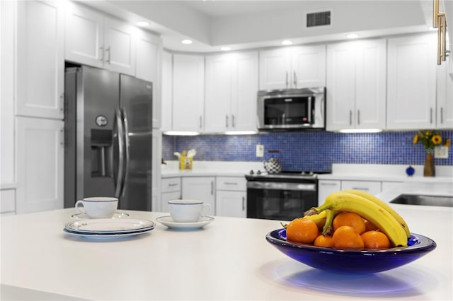 kitchen with white cabinetry, appliances with stainless steel finishes, sink, and backsplash