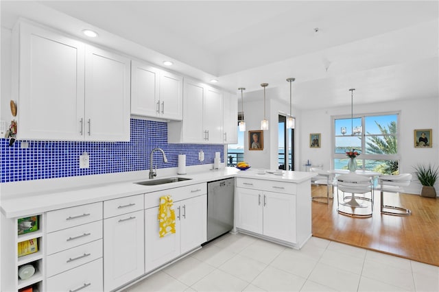 kitchen with sink, decorative light fixtures, stainless steel dishwasher, kitchen peninsula, and white cabinets