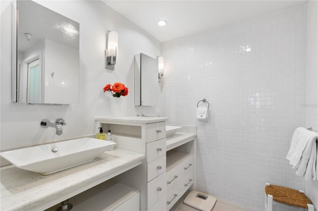 bathroom featuring vanity and tile walls