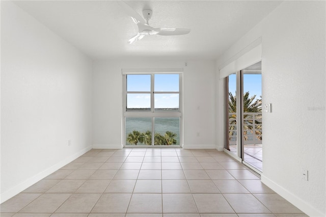 4993 Bacopa Ln S Unit 304, Saint Petersburg, FL 33715 - empty room featuring light tile patterned flooring, ceiling fan, baseboards, and plenty of natural light