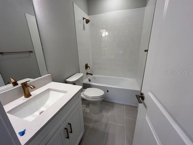 full bathroom featuring tiled shower / bath, vanity, toilet, and tile patterned flooring