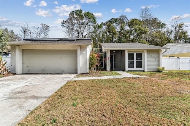 ranch-style home with a garage and a front lawn