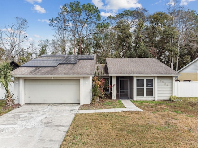 view of front of house featuring a garage, a sunroom, a front yard, and solar panels