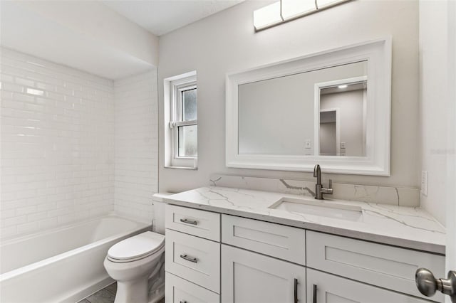 full bathroom with vanity, tiled shower / bath, and toilet