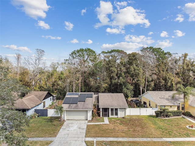 view of front of house with a garage, a front yard, and solar panels