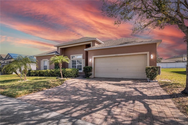 view of front of home featuring a garage and a lawn