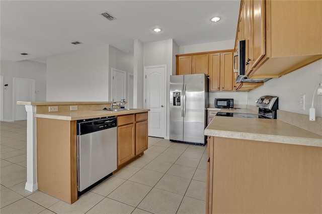 kitchen with appliances with stainless steel finishes, sink, an island with sink, and light tile patterned floors