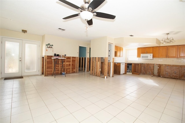 living room featuring french doors, light tile patterned flooring, and ceiling fan with notable chandelier