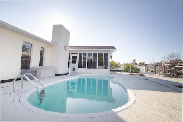 view of swimming pool with a sunroom and a patio