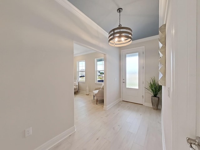 entrance foyer featuring ornamental molding and light wood-type flooring