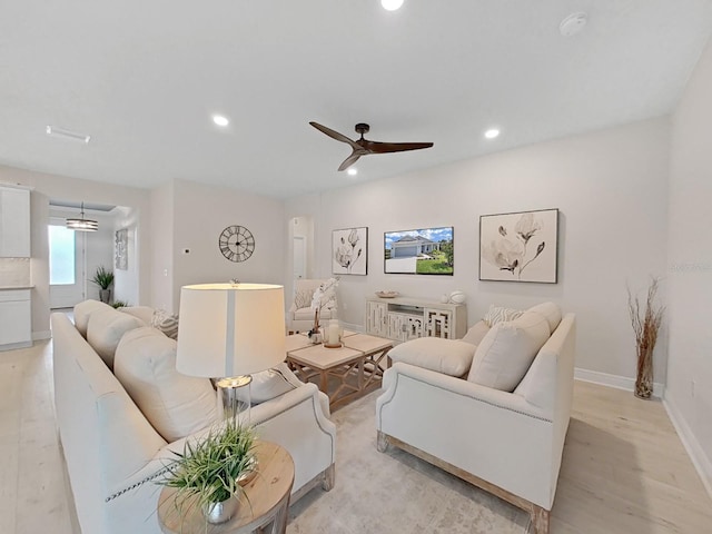 living room featuring ceiling fan and light hardwood / wood-style floors