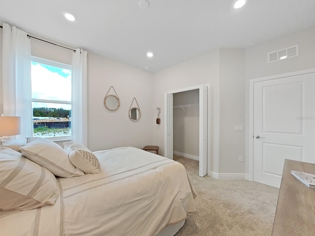 bedroom featuring light colored carpet and a closet