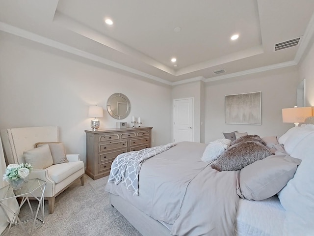 bedroom featuring light carpet, a tray ceiling, and crown molding