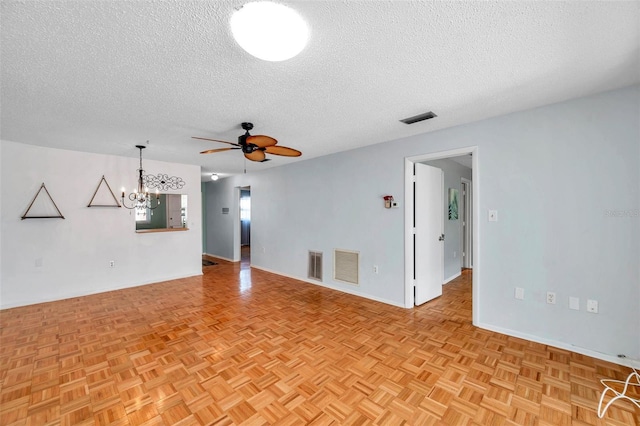 unfurnished living room featuring visible vents, a textured ceiling, and ceiling fan with notable chandelier