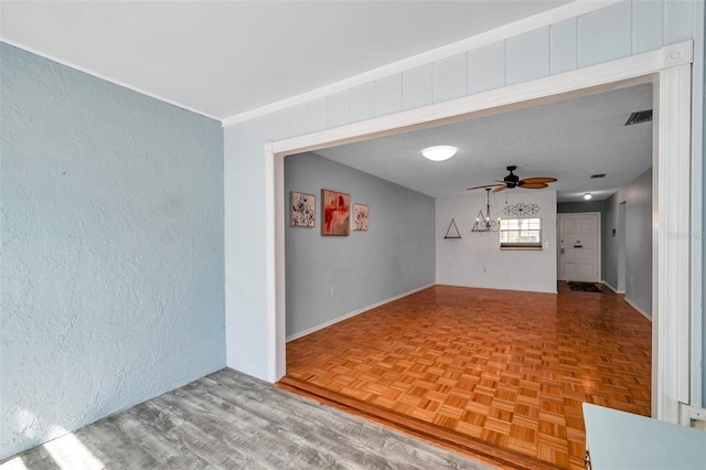 empty room with ceiling fan, parquet flooring, and visible vents