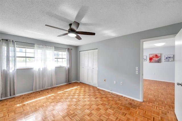 unfurnished room featuring ceiling fan, baseboards, and a textured ceiling