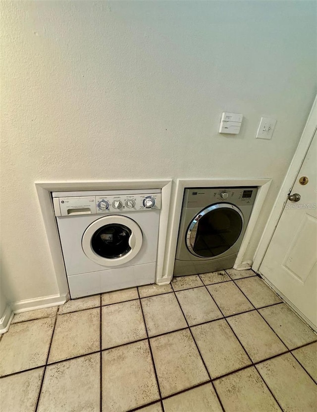 washroom featuring light tile patterned flooring and washer and clothes dryer