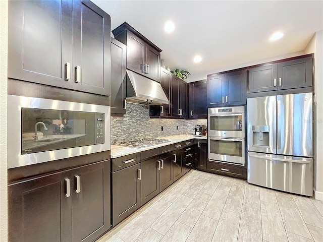 kitchen with recessed lighting, light countertops, decorative backsplash, appliances with stainless steel finishes, and under cabinet range hood